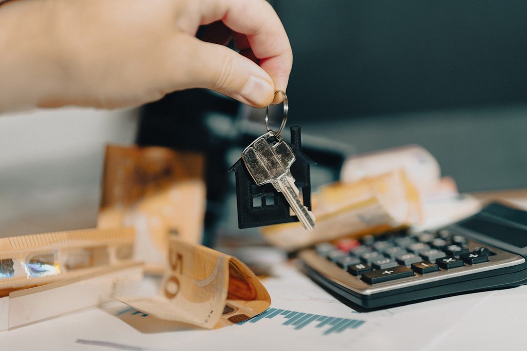 Home hand holding door keys real estate market home finance calculator documents analytics charts